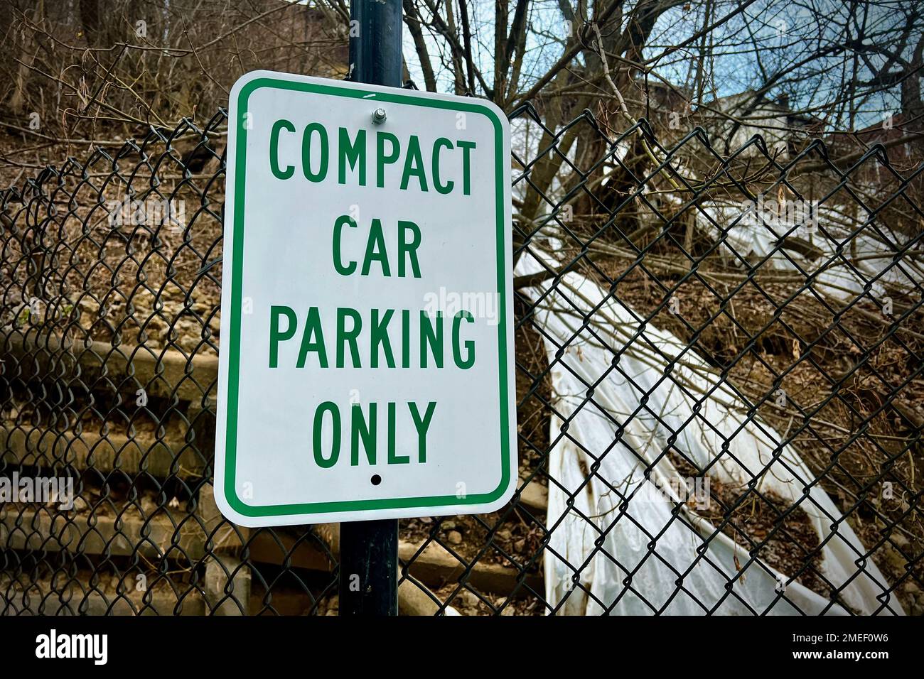 a-closeup-of-compact-car-parking-only-sign-on-a-mesh-fence-stock