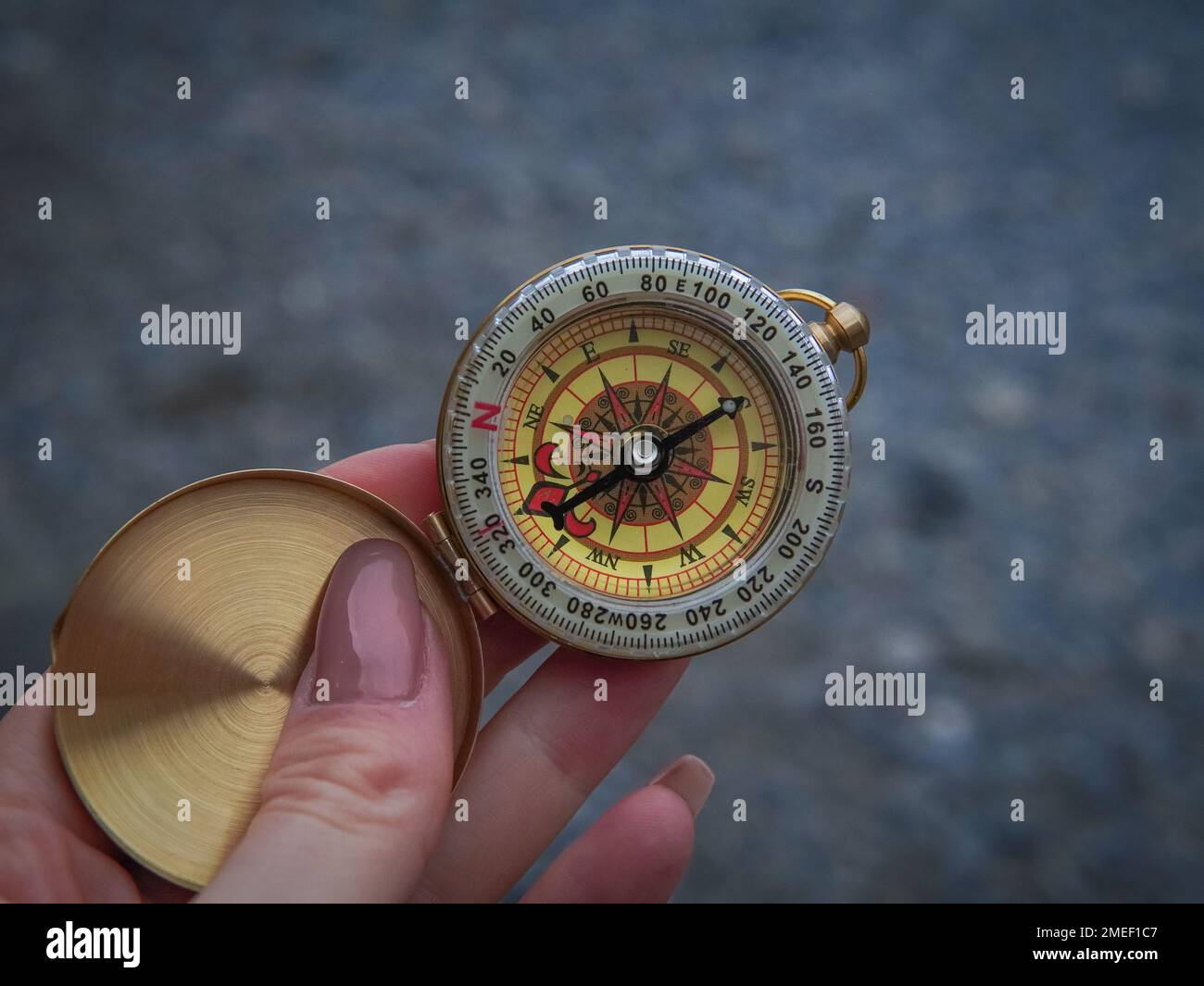 close up of golden compass in hand,streetb background Stock Photo - Alamy