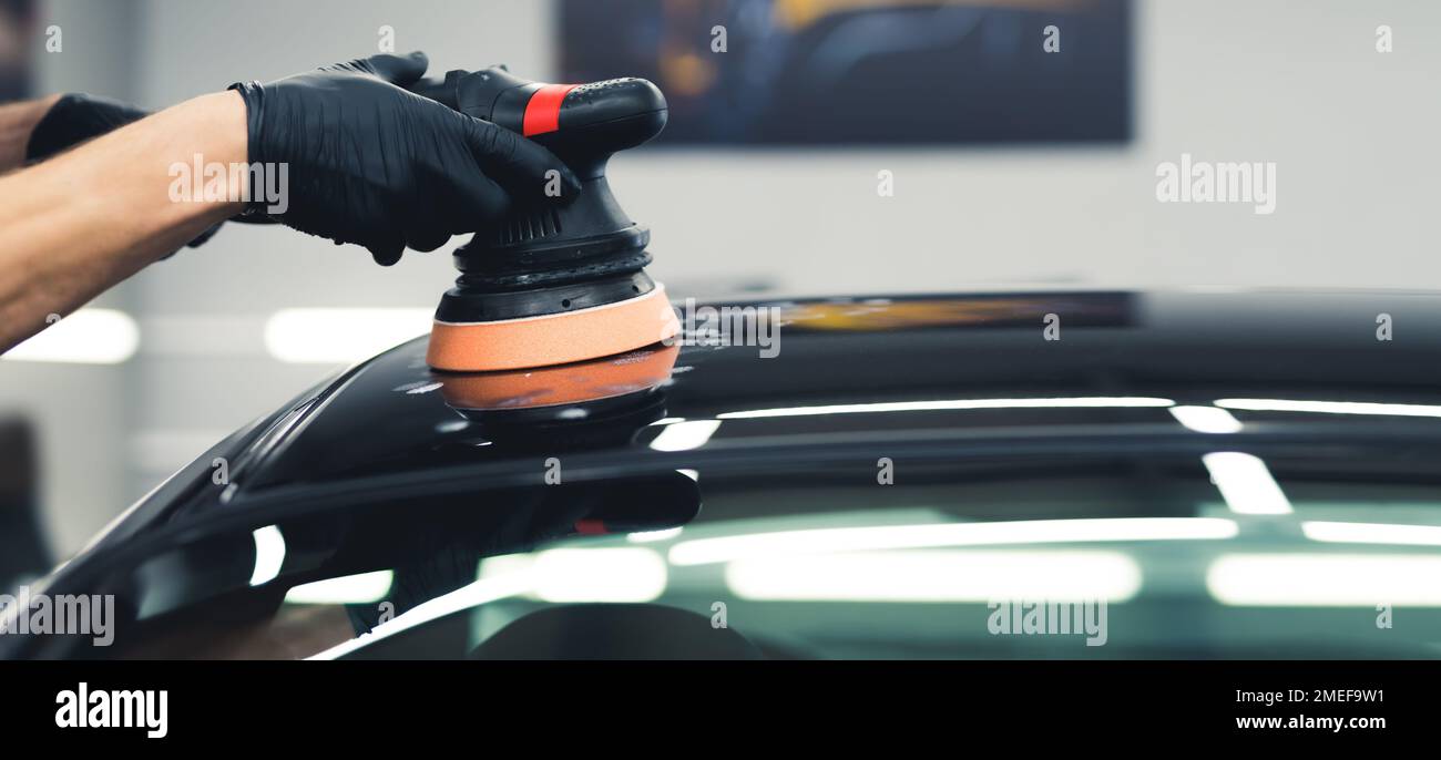 Unrecognisable man hands in black gloves holding professional buffer tool polishing paintjob on