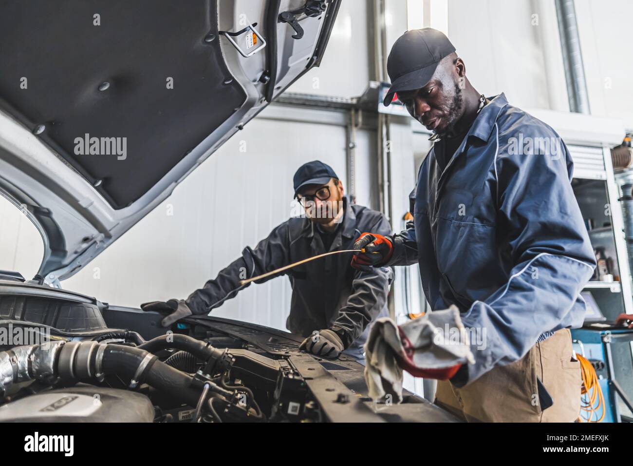 Skilled mechanics repairing a car engine using tools in a modern auto