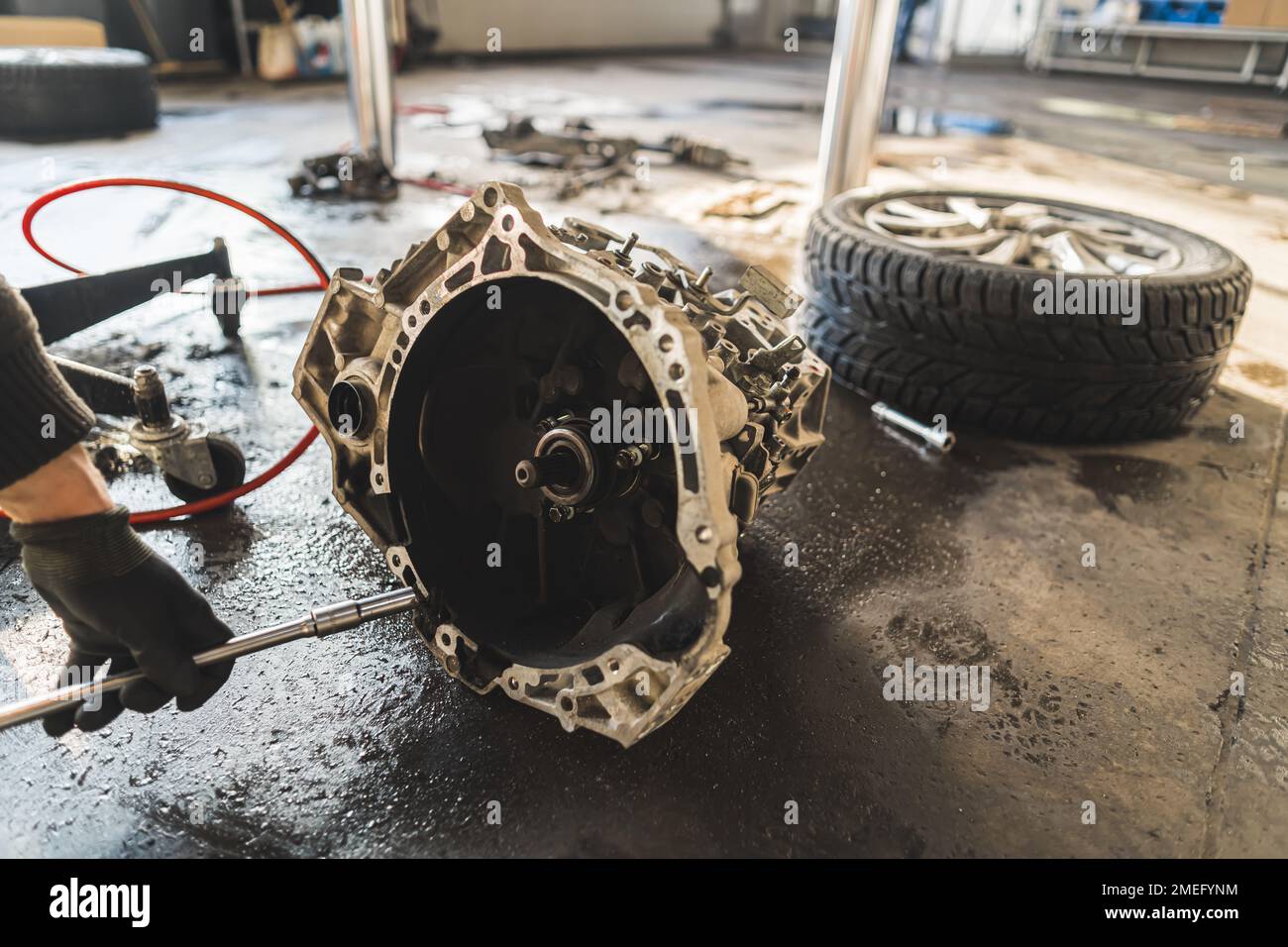 Close shot of a gearbox lying on the floor during clutch replacement