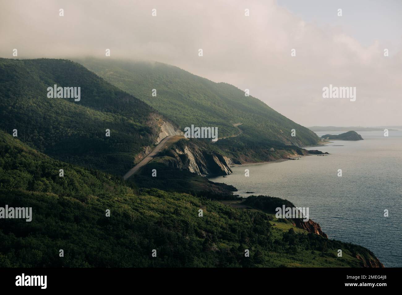 A aerial view of mountains covered with green forests against a sea on ...