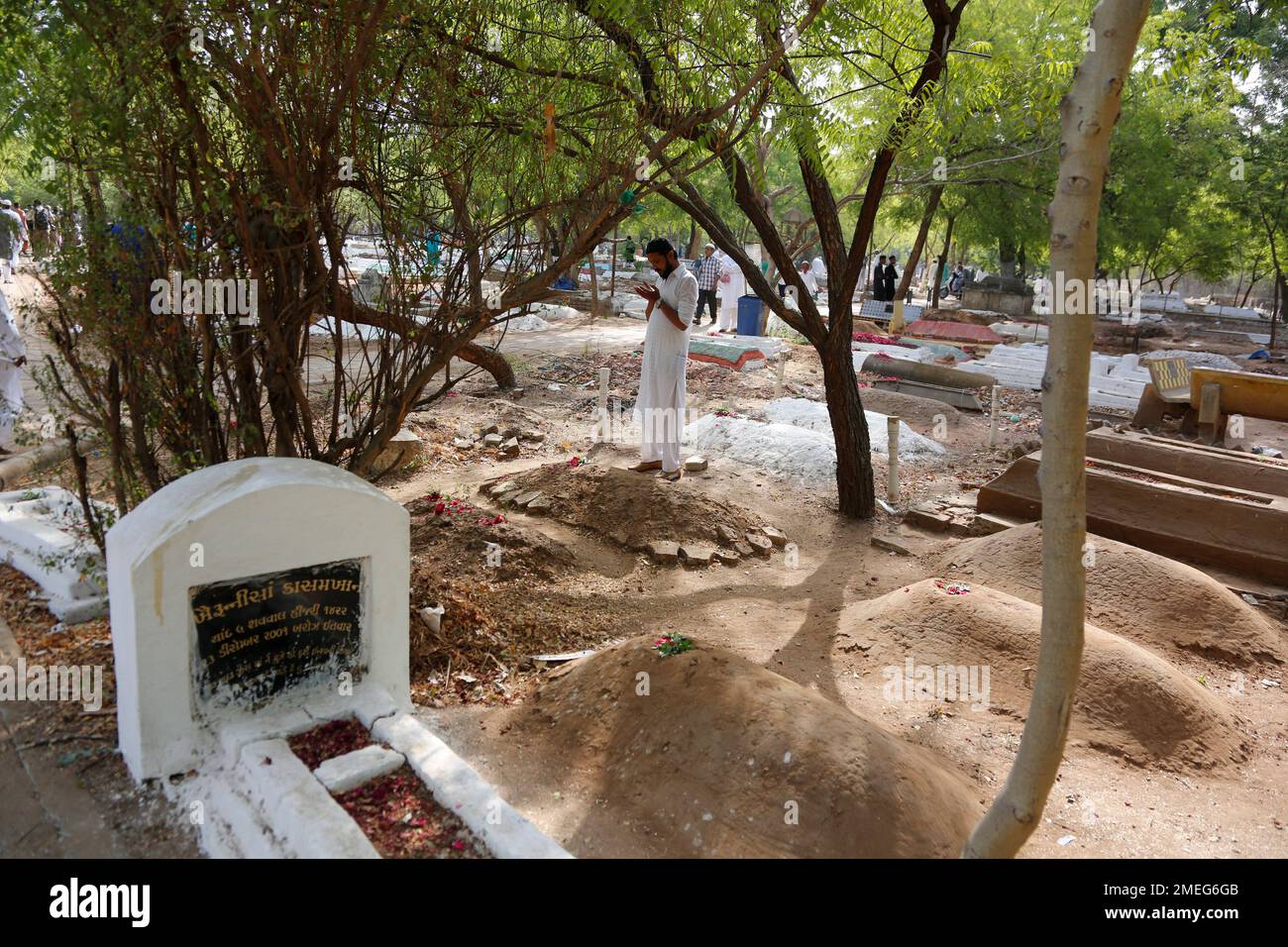 An Indian Muslim man offers prayers near the grave of his relative on