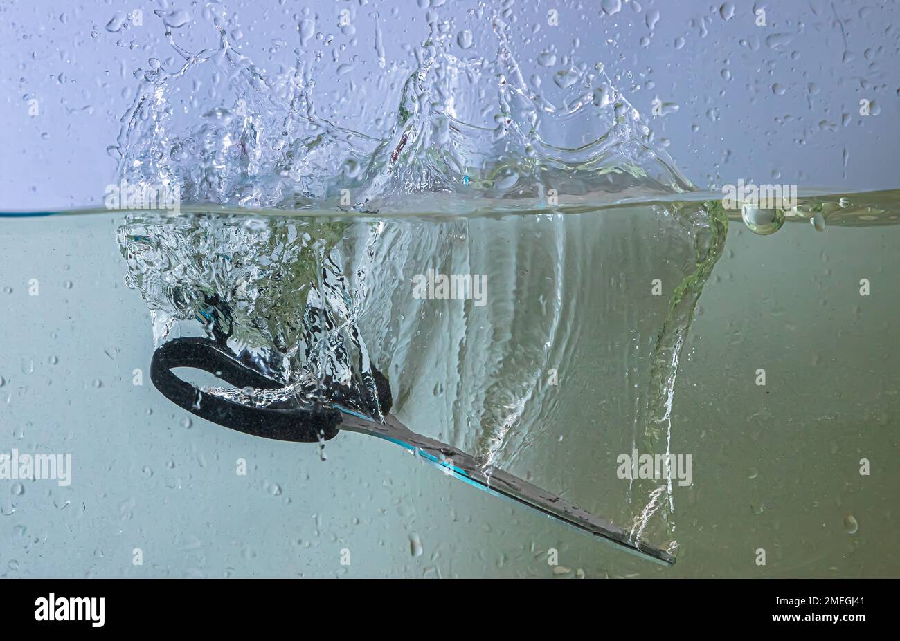 Fallingwithscissors scissors fall into the water. sprays, drops and bubbles Stock Photo - Alamy