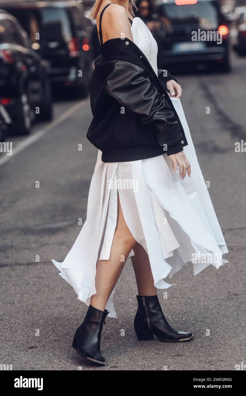 Milan, Italy - February 25, 2022: Woman in white dress with brutal leather jacket and boots. Stock Photo