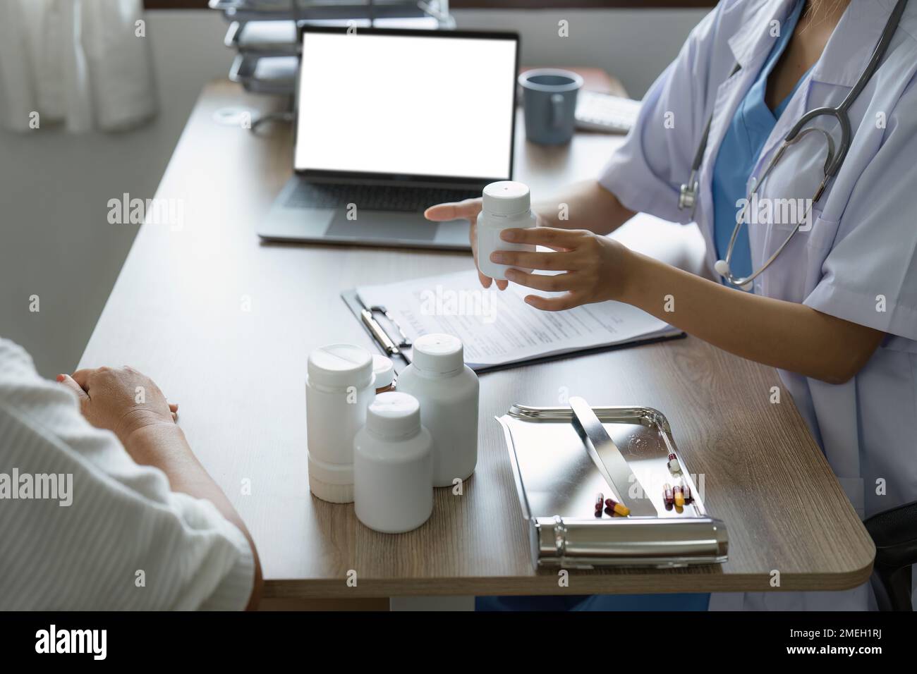 Doctor talking with elderly asian woman. Female primary care physician having conversation with older woman. Elderly Healthcare Stock Photo
