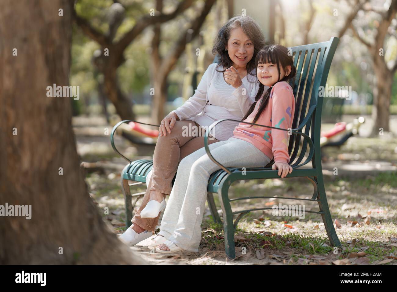 Asian Grandmother and Granddaughter having activity together outdoor park. Hobbies and leisure, lifestyle, family life, happiness moment concept Stock Photo
