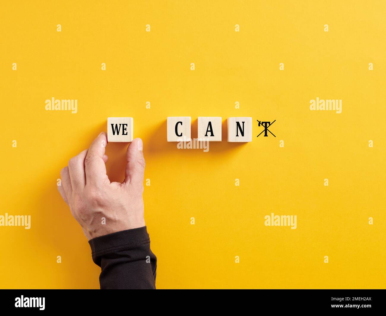 Hand changing the message we can't into we can. Self motivation, ambition, goal achievement, determination and overcoming difficulties. Stock Photo