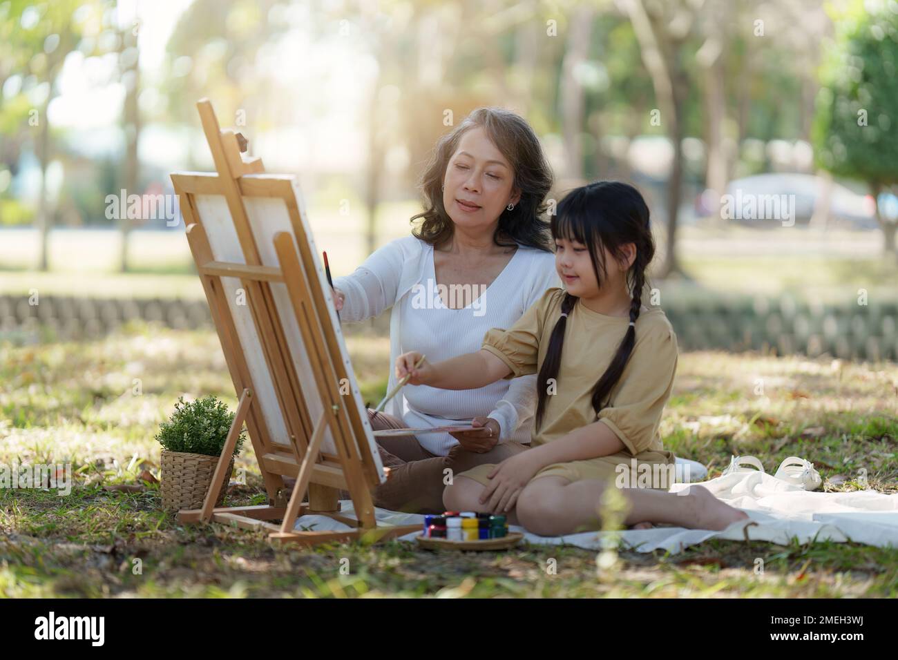 Asian Grandmother and Granddaughter having activity together outdoor park. Hobbies and leisure, lifestyle, family life, happiness moment concept Stock Photo