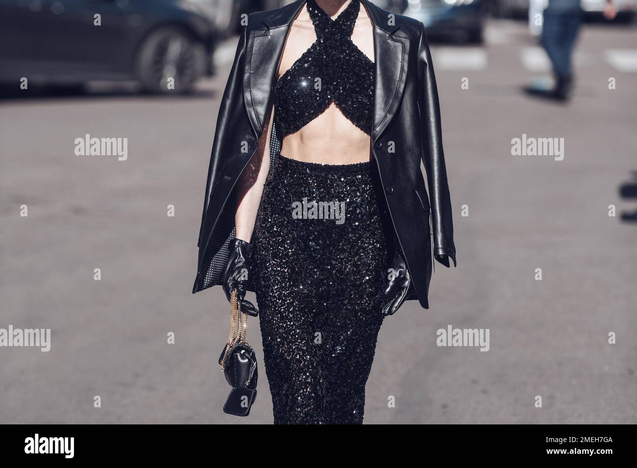 Milan, Italy - February 26, 2022: Female wearing a black glitter dress, black purse and elegant shoes. Stock Photo