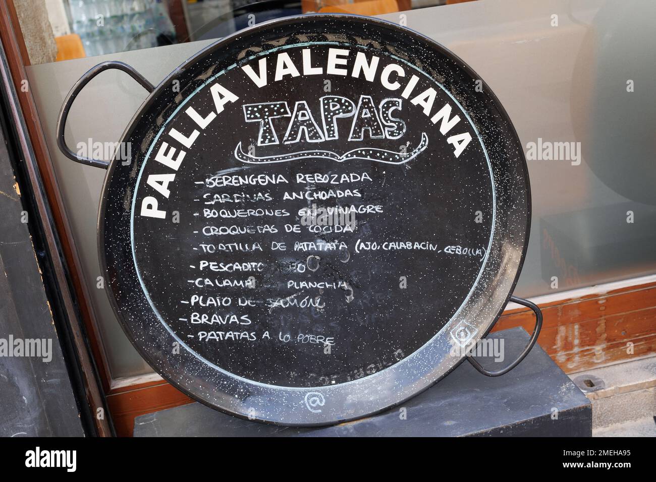 spanish-bar-menu-written-on-a-large-black-typical-pan-used-for-cooking
