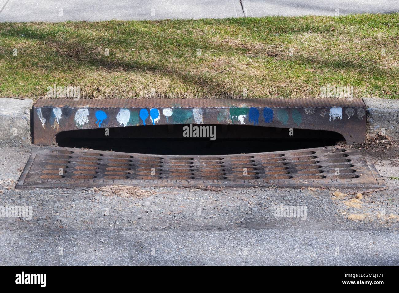 A New York City sewer drain with mysterious markings which in fact indicate the larvicides sprayed to limit the mosquito problem. In Queens, New York. Stock Photo