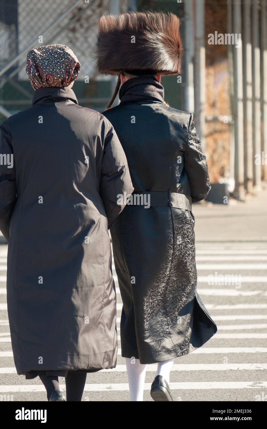 On a Friday afternoon an anonymous couple head home with him dressed in his Sabbath clothes and her not yet. In Brooklyn, New York. Stock Photo