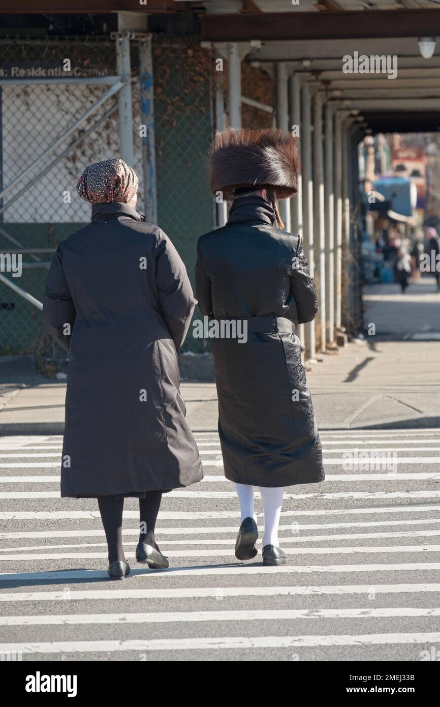 On a Friday afternoon an anonymous couple head home with him dressed in his Sabbath clothes and her not yet. In Brooklyn, New York. Stock Photo