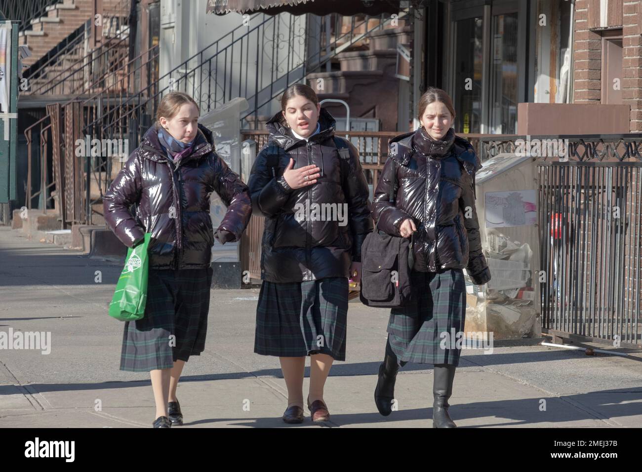 3 orthodox Jewish school girls walk home together wearing the same plaid skirt, their school's uniform. In Brooklyn, New York, 2023 Stock Photo