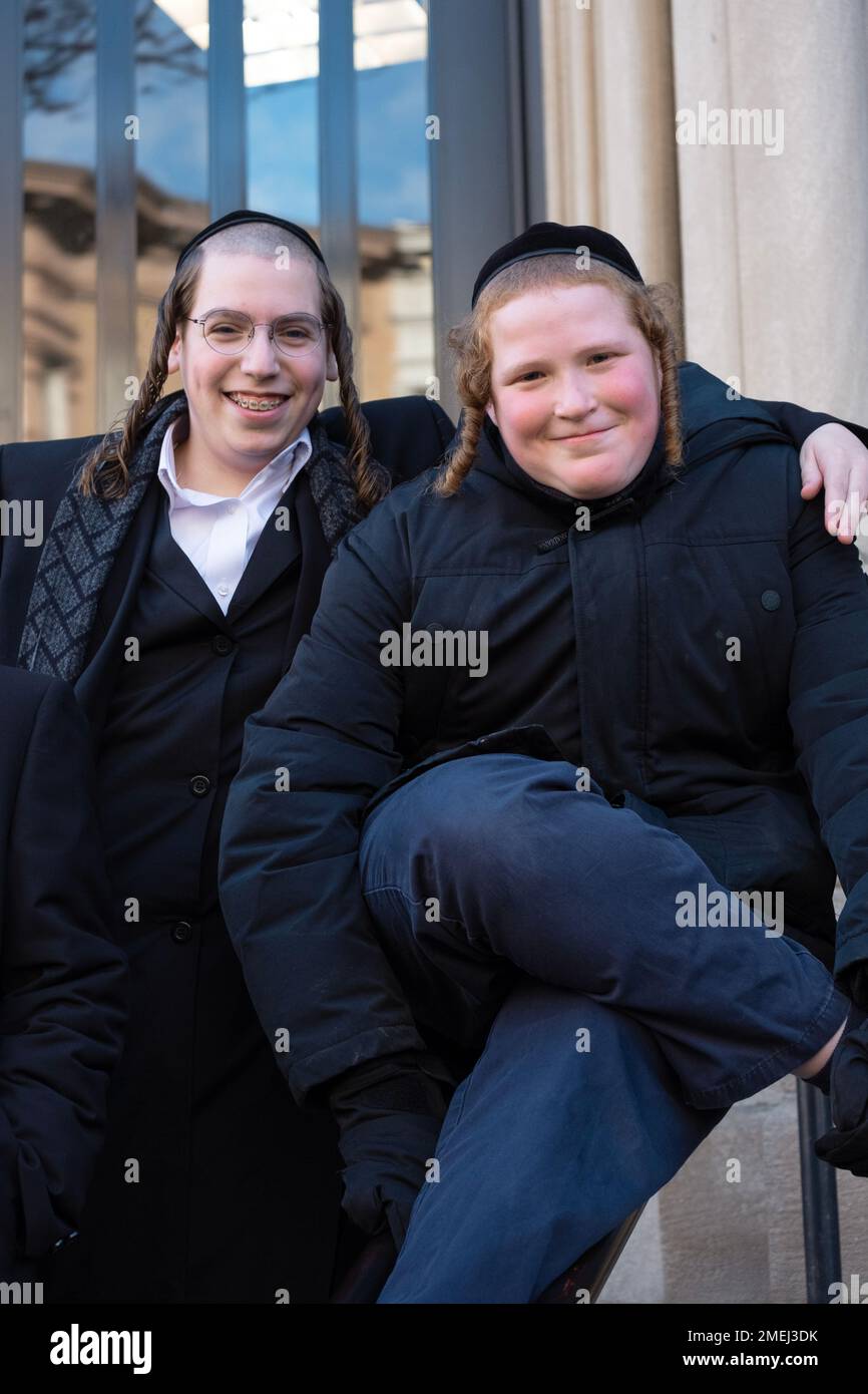 During recess, 2 orthodox Jewish yeshiva students flash a smile while posing for a photo on their yeshiva's steps. In Brooklyn, New York City. Stock Photo