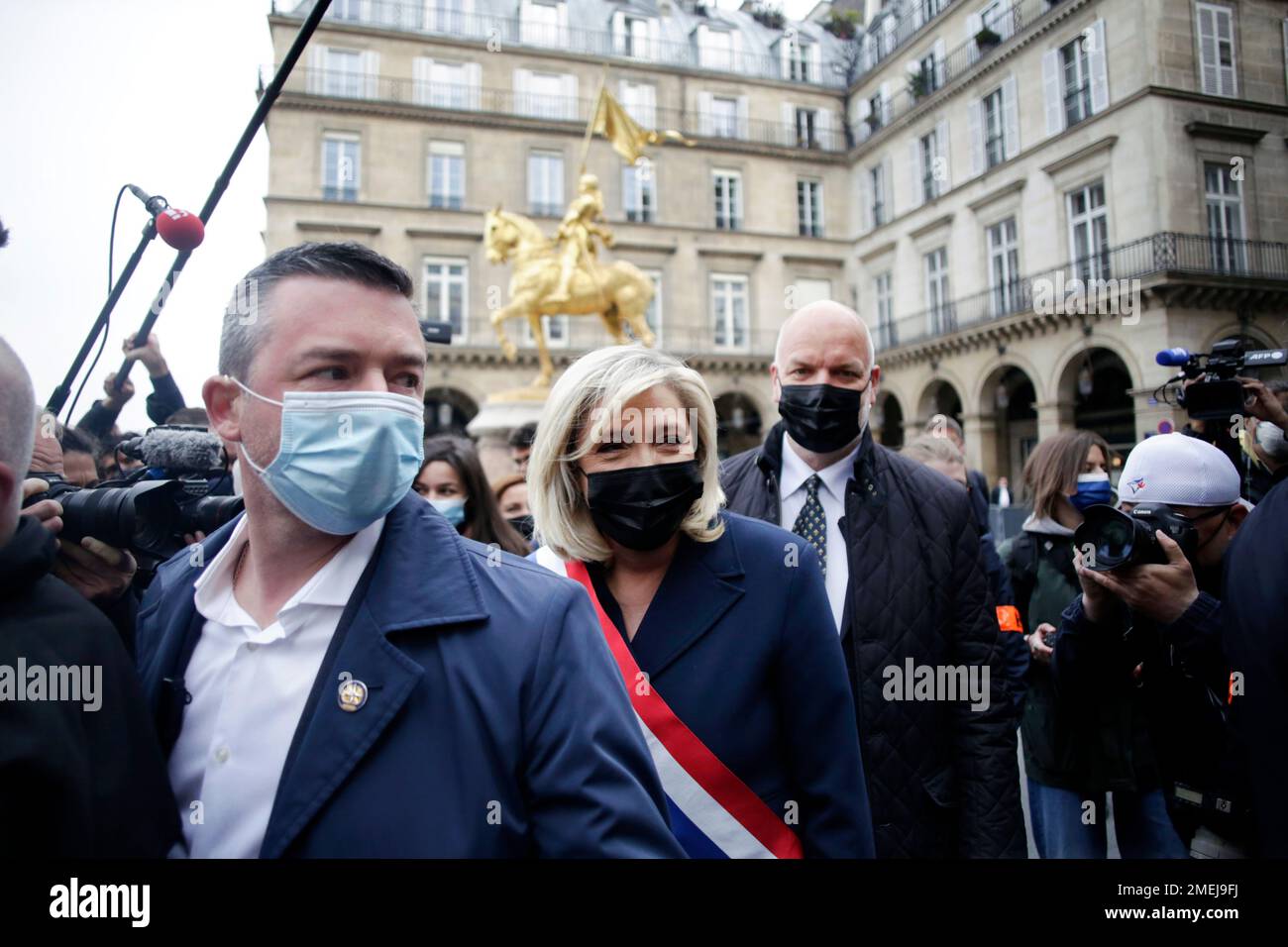 French far-right leader Marine le Pen, center, wearing a protective face  mask, leaves the statue of Joan of Arc after laying a wreath during a  ceremony Saturday, May 1, 2021 in Paris.