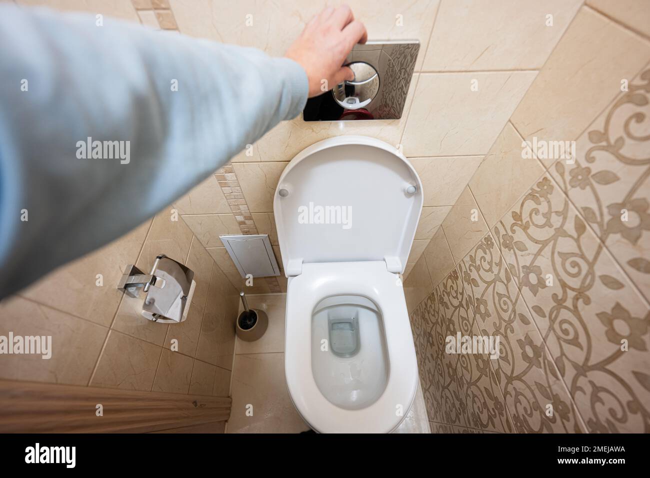 Hand of man push toilet flush press with two separate buttons Stock