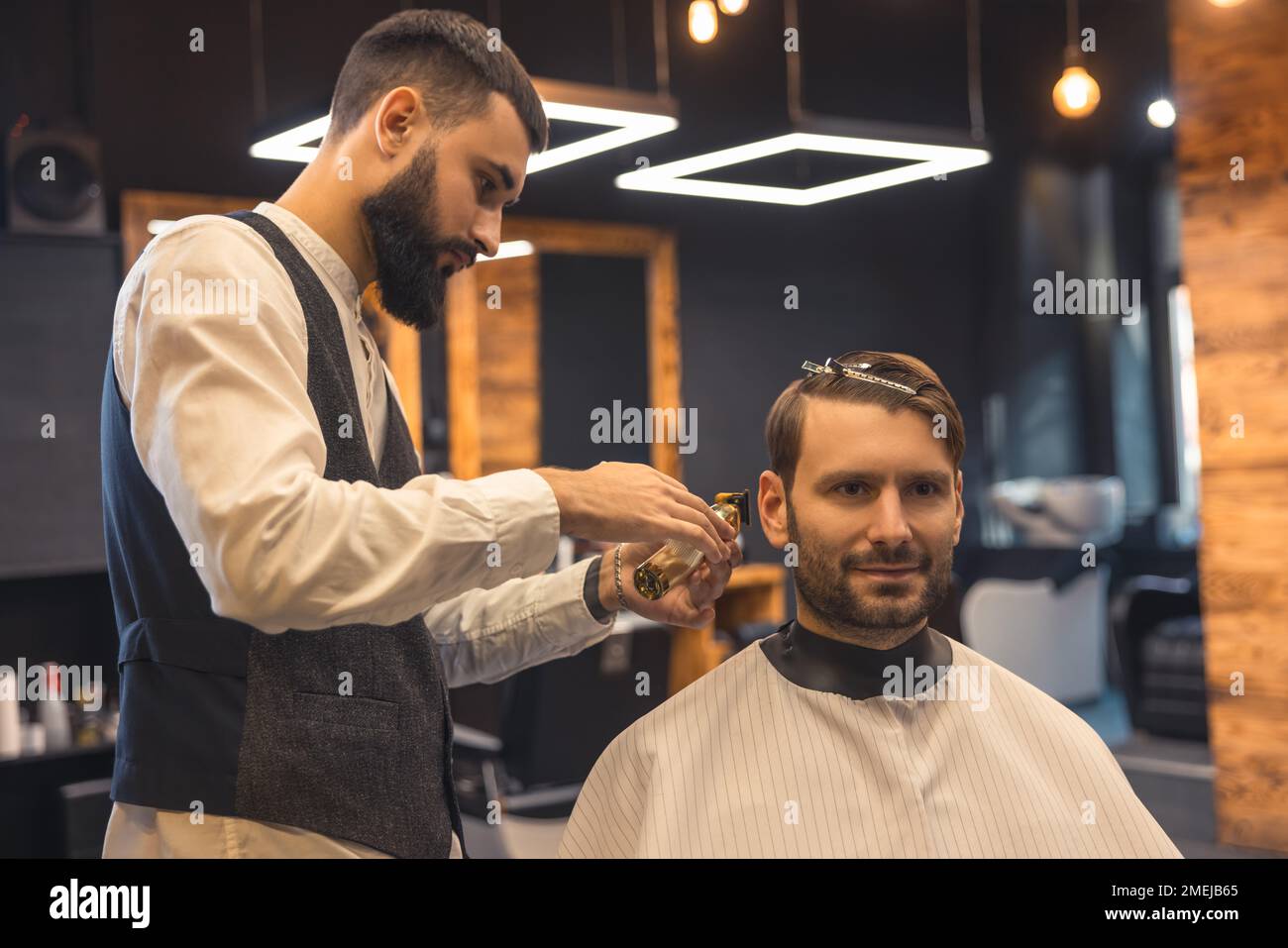 Barber trimming shaving cleints neck with electric razor Stock Photo