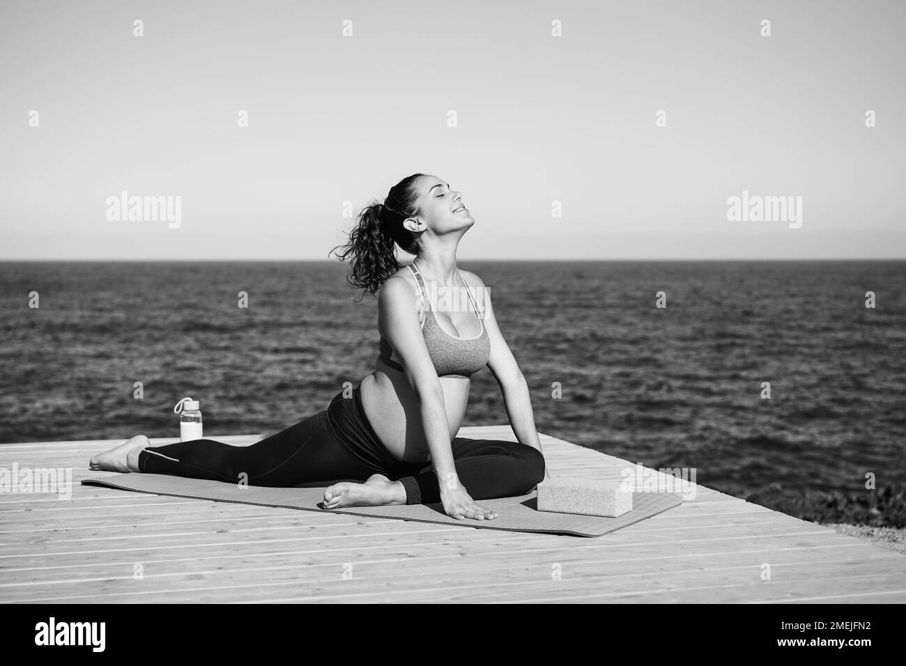 Young pregnant woman doing yoga outdoor - Maternity concept - Focus on face - Black and white editing Stock Photo