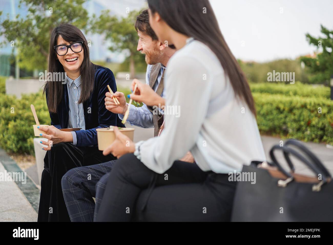 business people doing lunch break outdoor from office building - Focus on left girl face Stock Photo