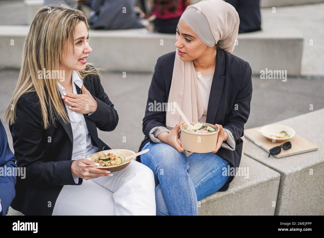 Multiracial business people doing lunch break outdoor from office building - Soft focus on arabian woman eyes Stock Photo