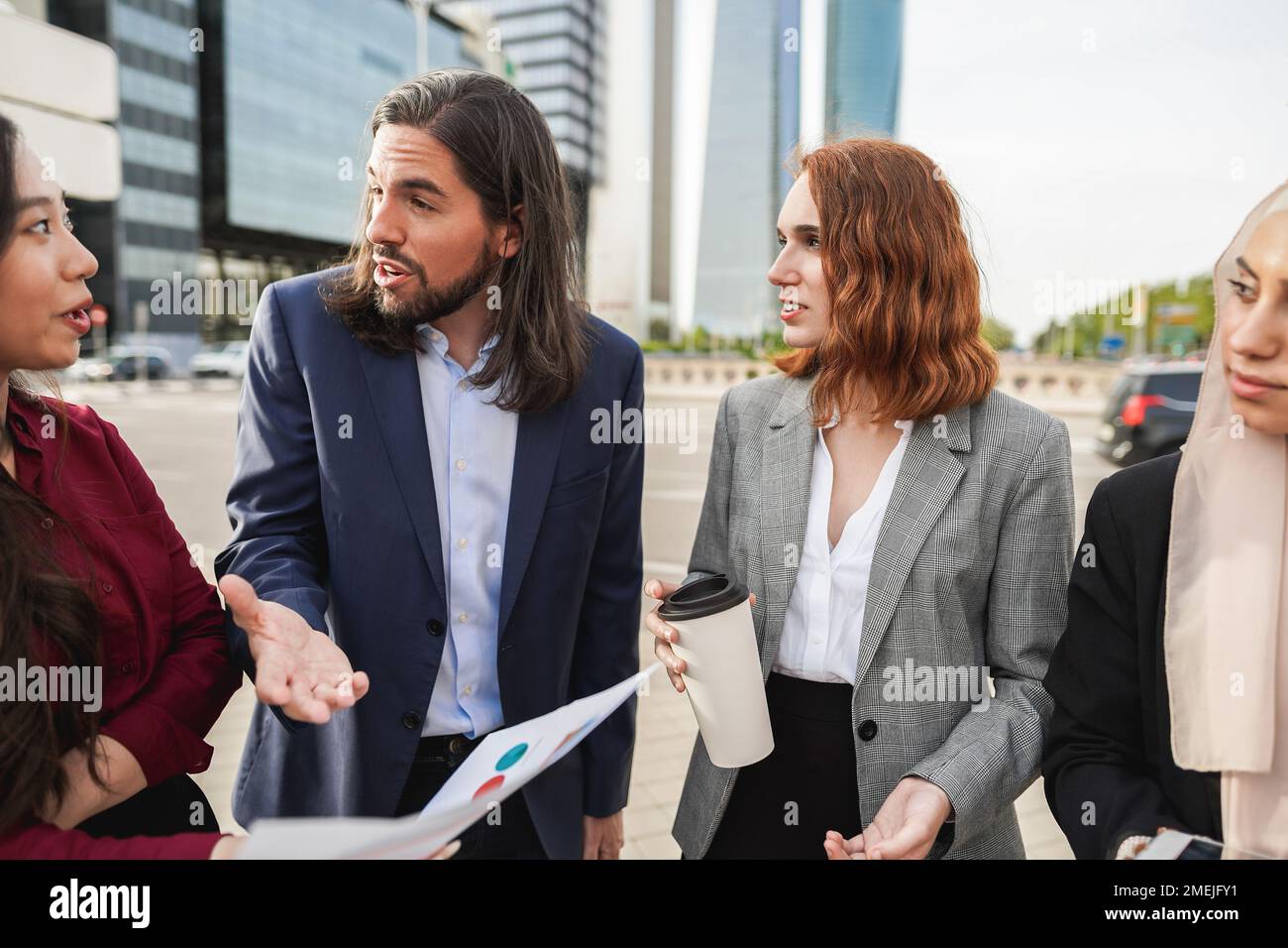 Multiracial business people working outdoor from office building - Focus on center woman face Stock Photo
