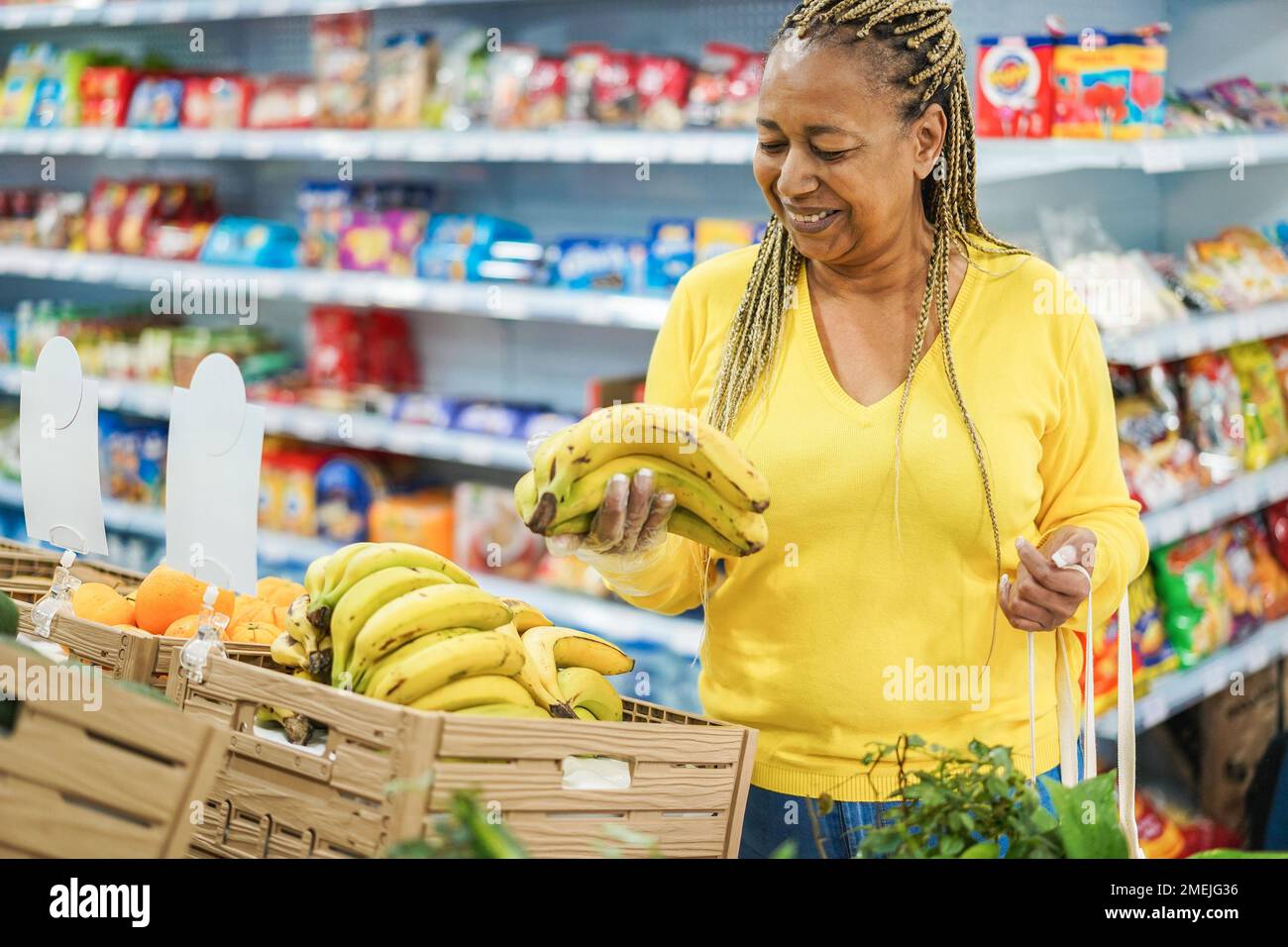 African female customer buying organic food fruits inside eco fresh market - Focus on woman face Stock Photo