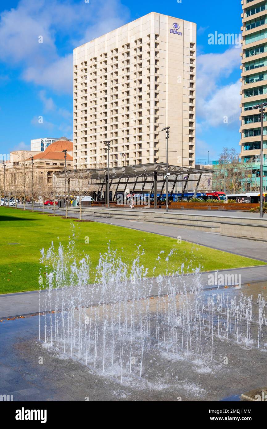 Adelaide City, South Australia - August 19, 2019: Victoria Square fountain on a day with Hilton Hotel in the background viewed on a bright day Stock Photo