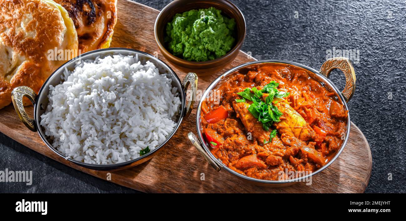 Butter chicken with rice and naan flatbread served in original indian karahi pots. Stock Photo
