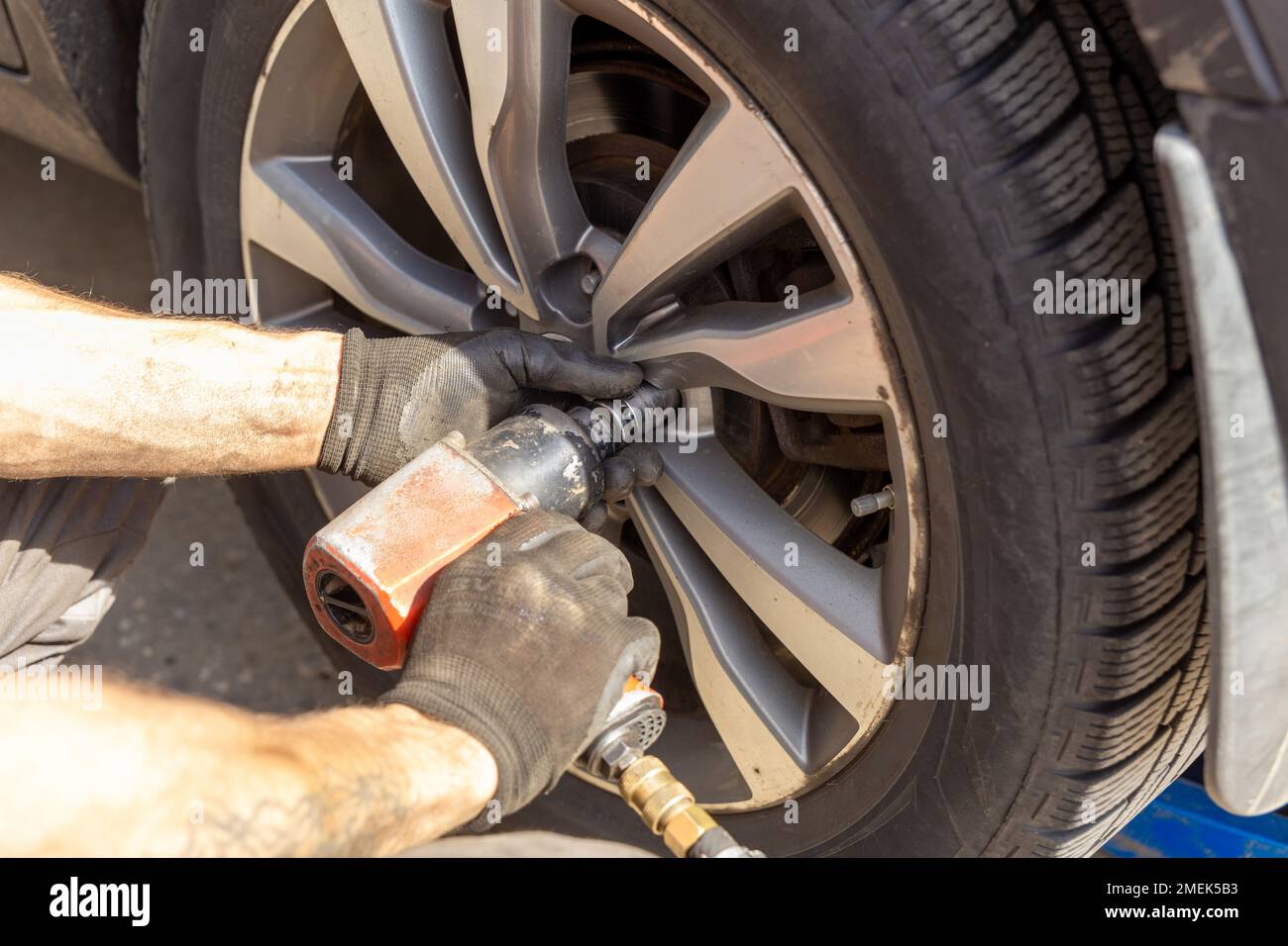 Seasonal Tires Replacement Automotive Photo Theme. Tire Sales Worker