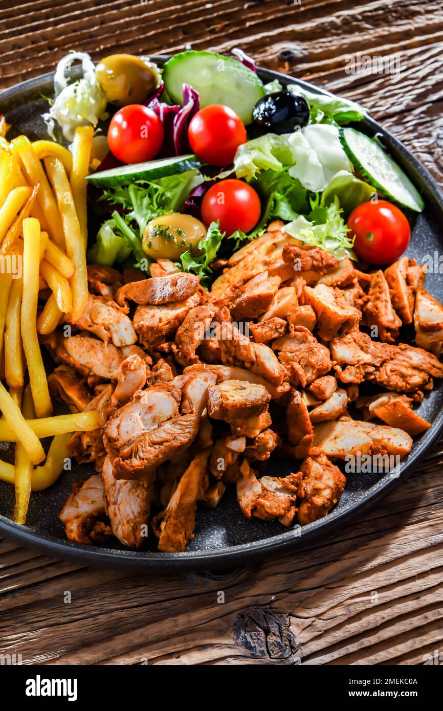 Kebab served with french fries, vegetable salad and tzatziki Stock Photo