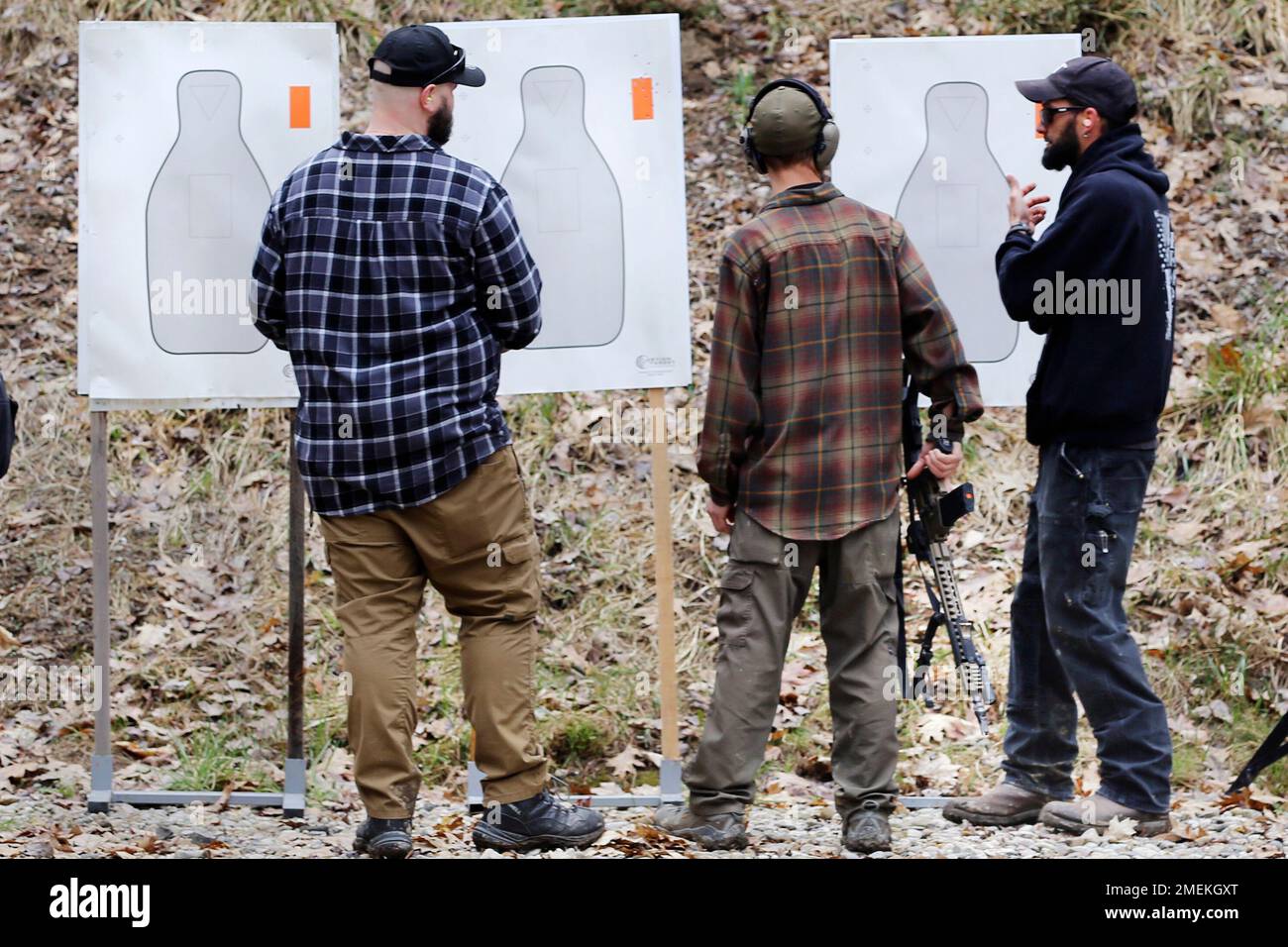 People look at targets during a pause in a shooting session at Slate