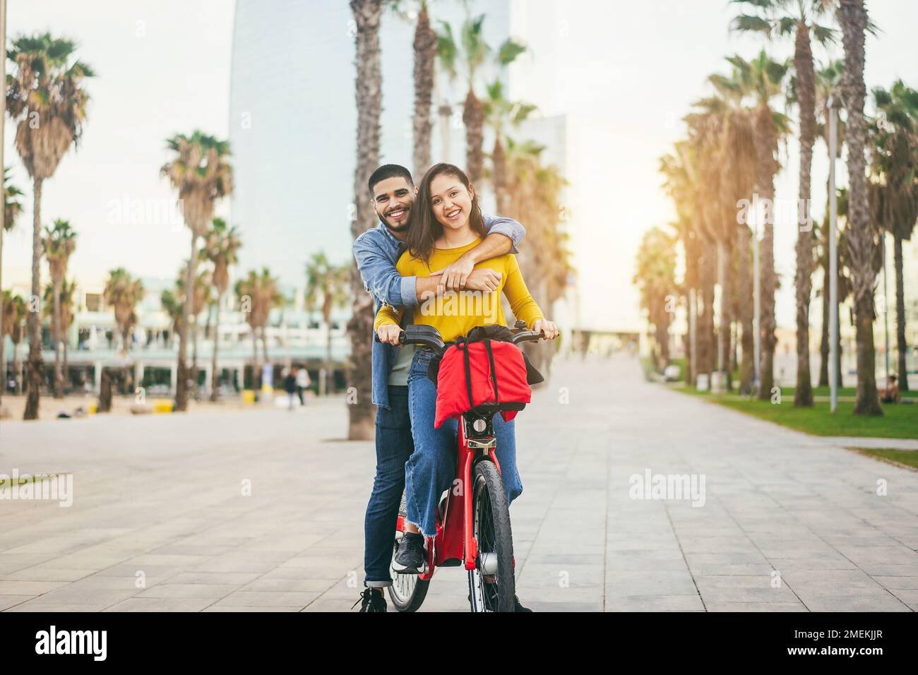 Happy hispanic people having fun with electric bike outdoor - Focus on faces Stock Photo