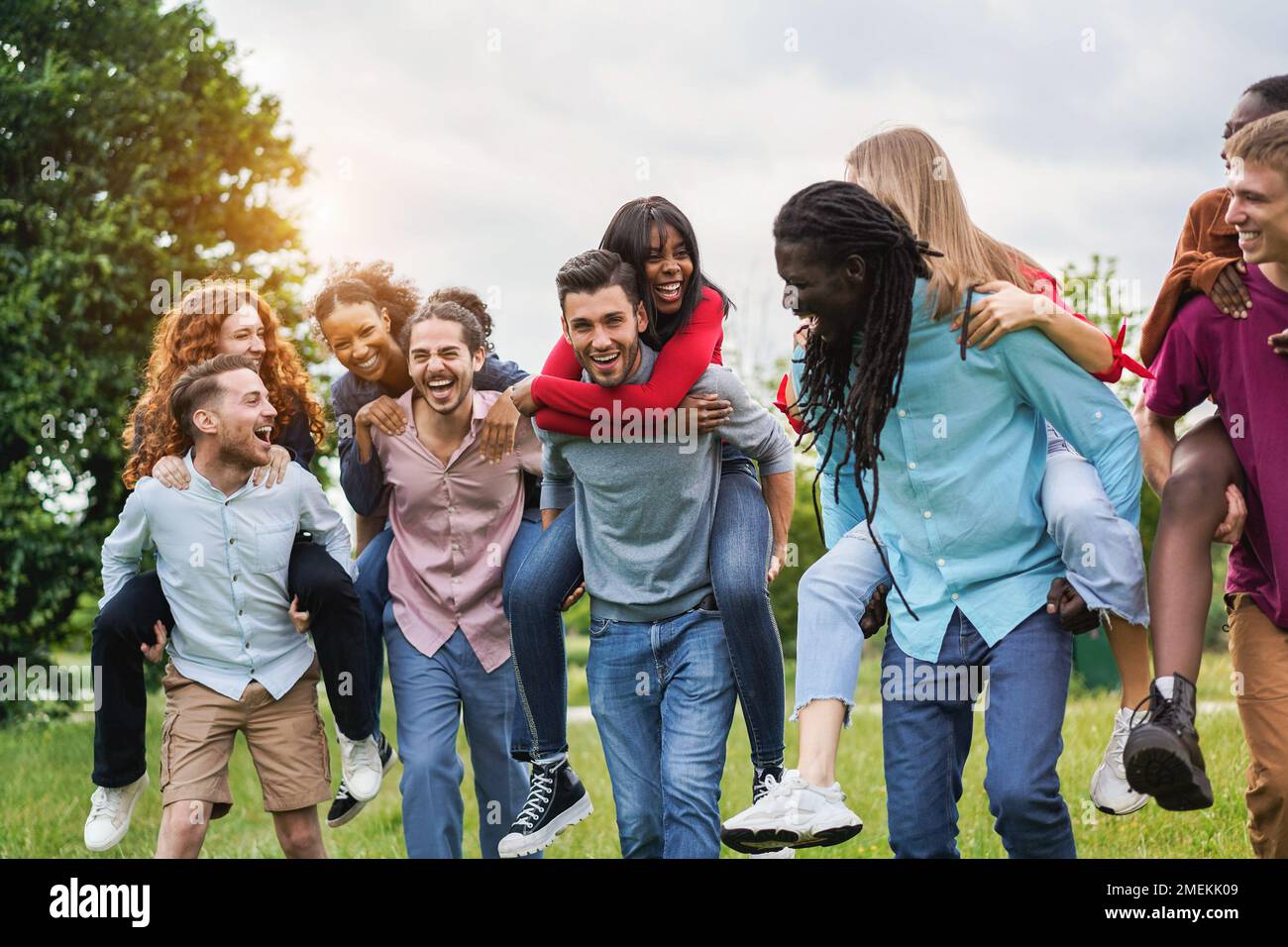 Young diverse friends having fun outdoor laughing together - Focus on center african girl face Stock Photo