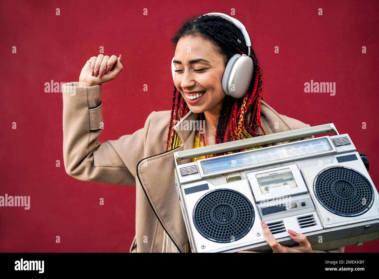 African girl dancing listening music in spring time outdoors - Focus on headphones Stock Photo