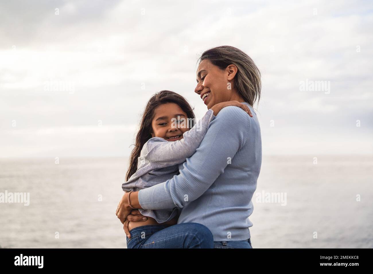 Happy latin mother and daughter having fun together outdoor - Main focus on mother eye Stock Photo