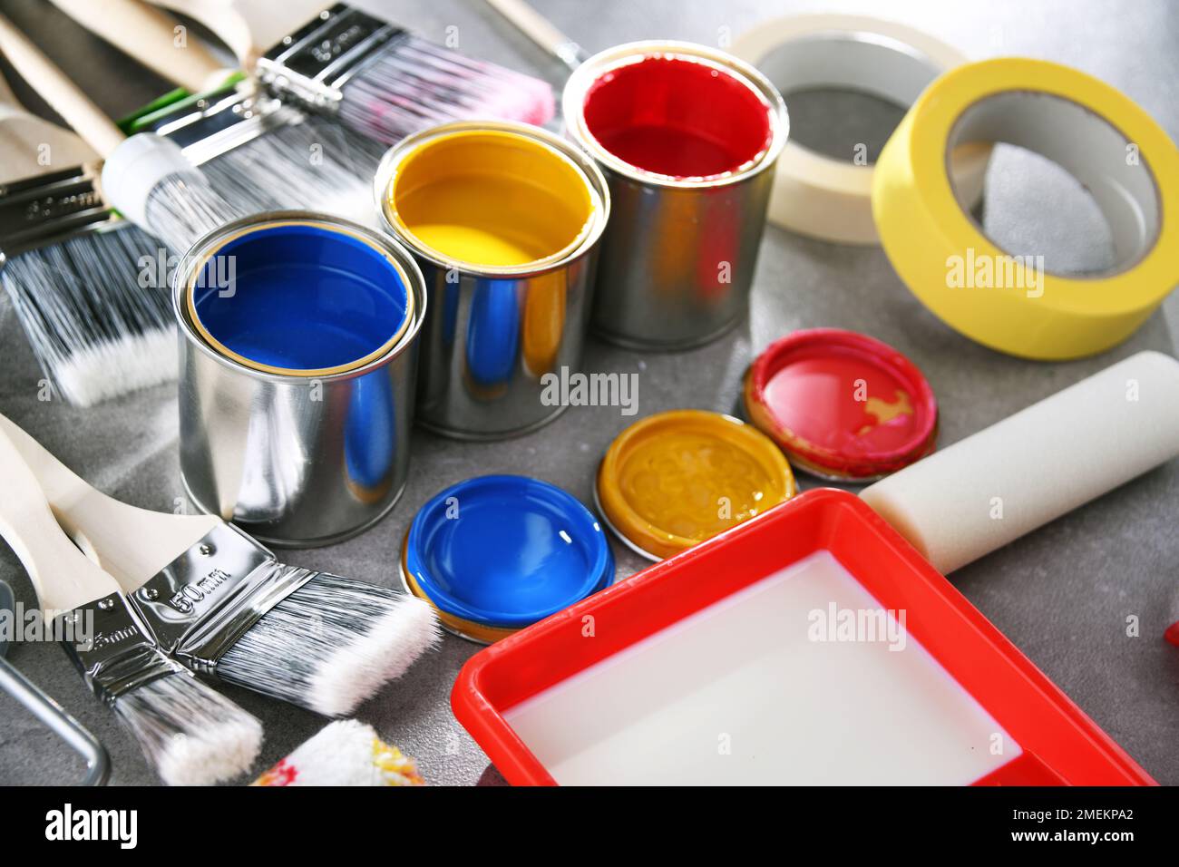 Paint cans and paintbrushes of different size  for home decorating purposes. Stock Photo