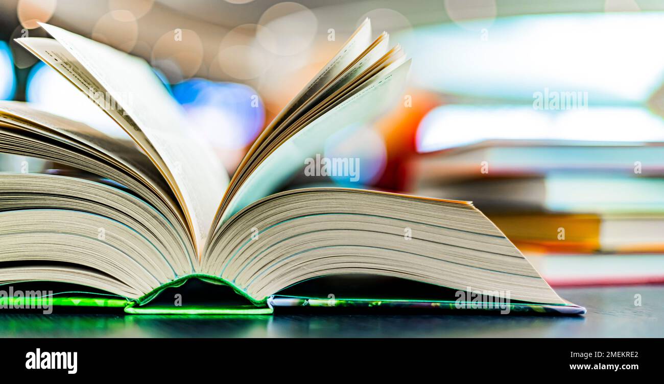 An open hardcover book on a table in a public library Stock Photo