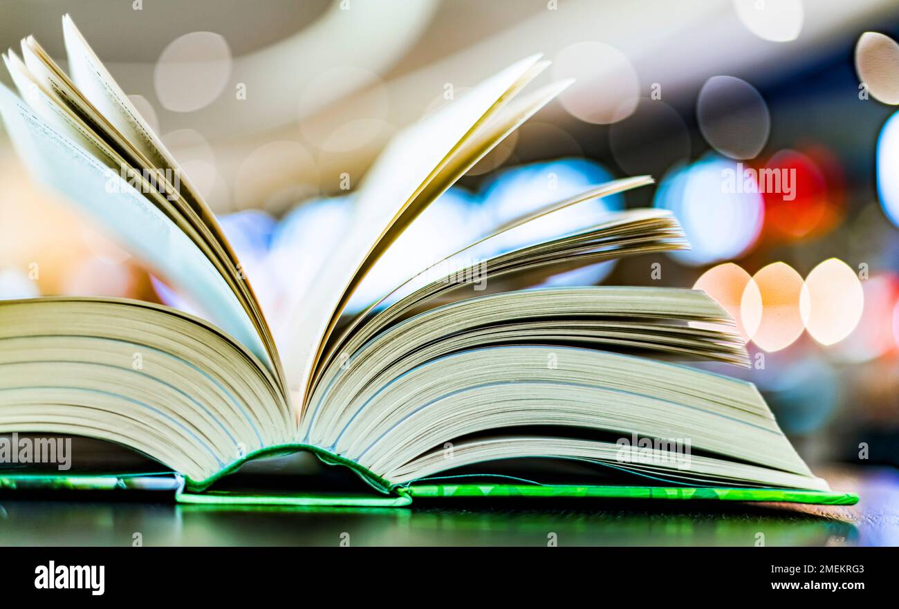 An open hardcover book on a table in a public library Stock Photo