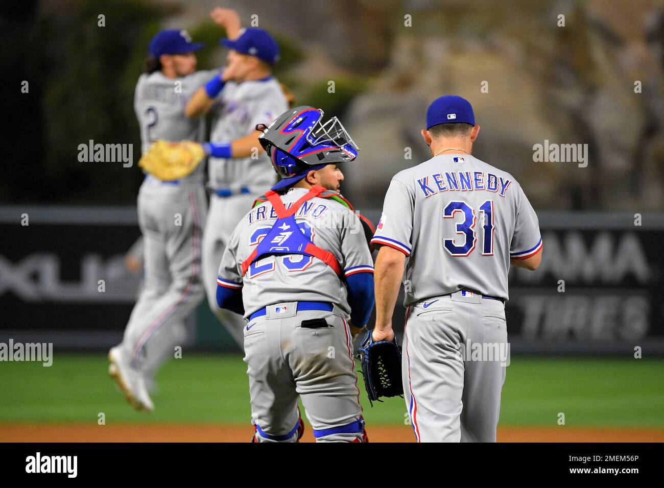 Texas Rangers catcher Jose Trevino, left, and relief pitcher Ian Kennedy,  right, congratulate each other as players celebrate in the background after  the Rangers defeated the Los Angeles Angels 6-4 in a