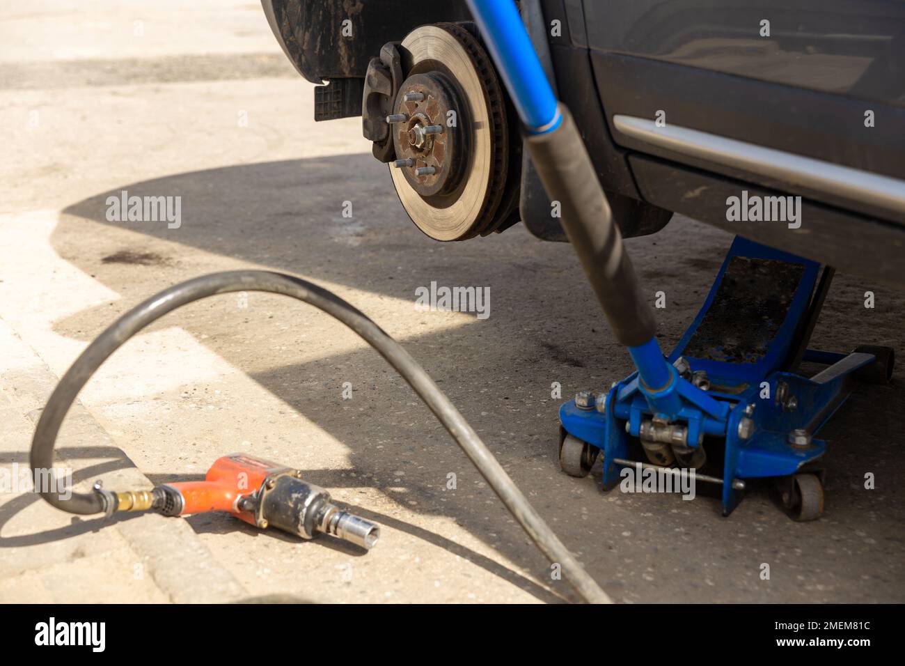 Hydraulic car jack lift the new car for change the tyre. Seasonal tyre ... - Nighttime Car Tire Changing With A Vehicle Lift