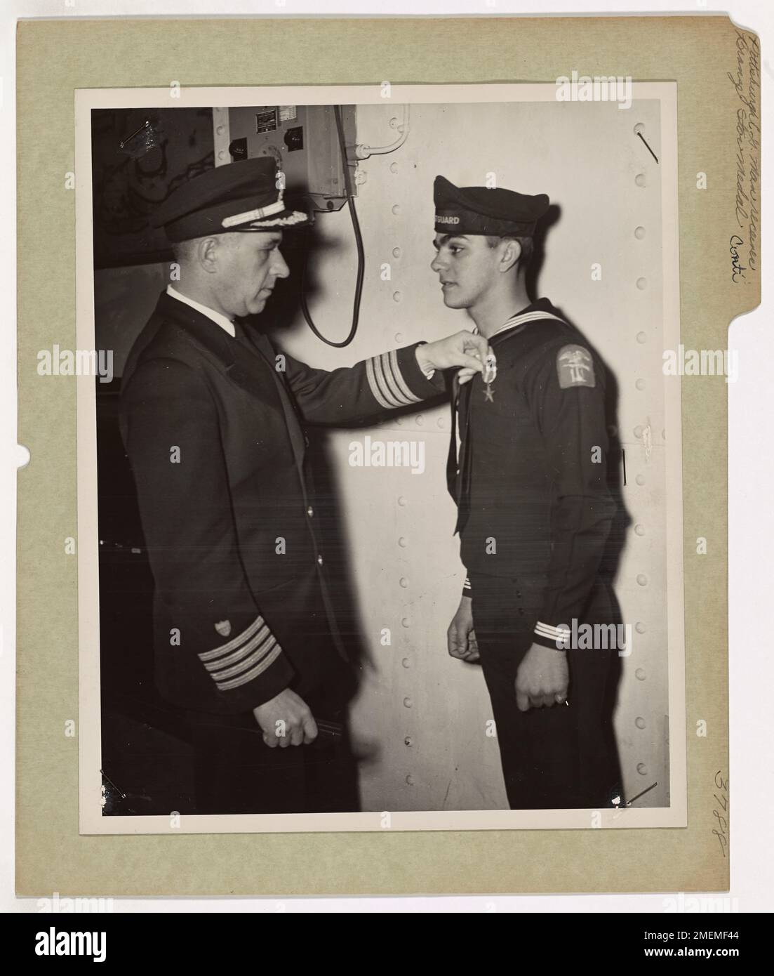 Pittsburgh Coast Guardsman Awarded Bronze Star Medal. Cited in the name of the President by Admiral Harold R. Stark, Commander of U. S. Naval forces in Europe, Coast Guardsman Edward P. Conti, Coxswain, of 219 Pearl Street, Pittsburgh, PA., is presented with the Bronze Star Medal by Captain Frank A. Leamy, 62 Woodmont Road, Belle Haven, Alexandria, VA. Serving as the Coxswain of a landing barge off the Coast Guard-manned invasion transport on which he was assigned, Coast Guardsman Conti rescued the entire troop detachment of a sinking LCI after debarking his own troops and fetching to other st Stock Photo