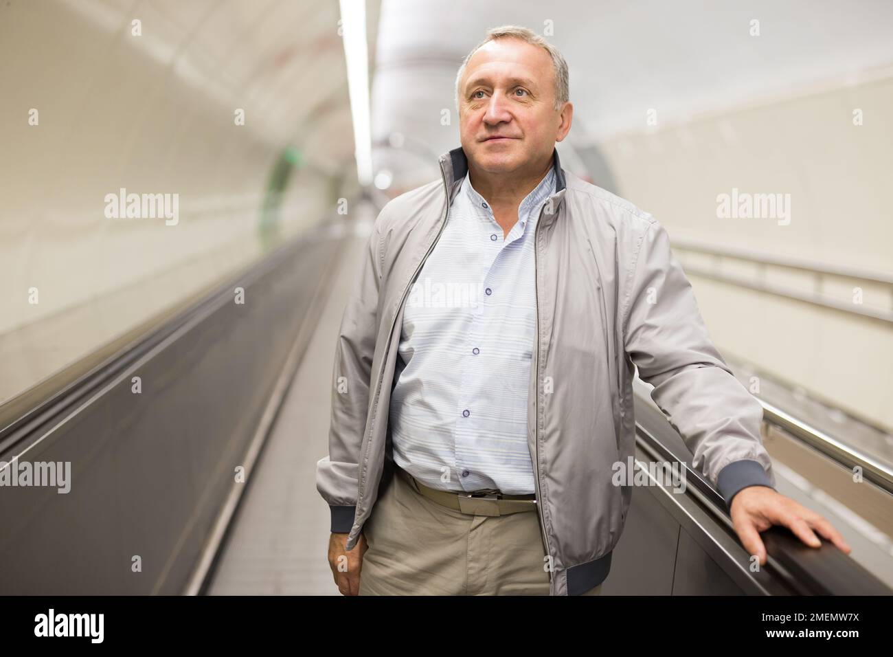 Middle aged man on moving walkway Stock Photo