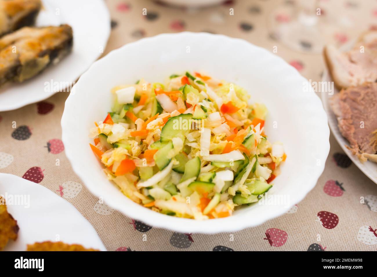 mix of vegetables. chopped cabbage, tomatoes, cucumbers, onions and greens in a bowl Stock Photo