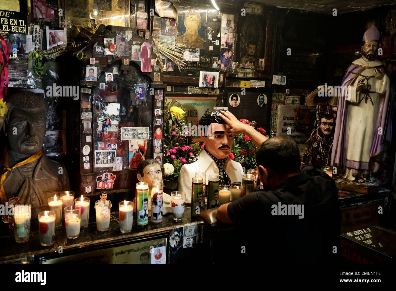 A man touches a statue of Jesus Malverde inside the shrine dedicated to