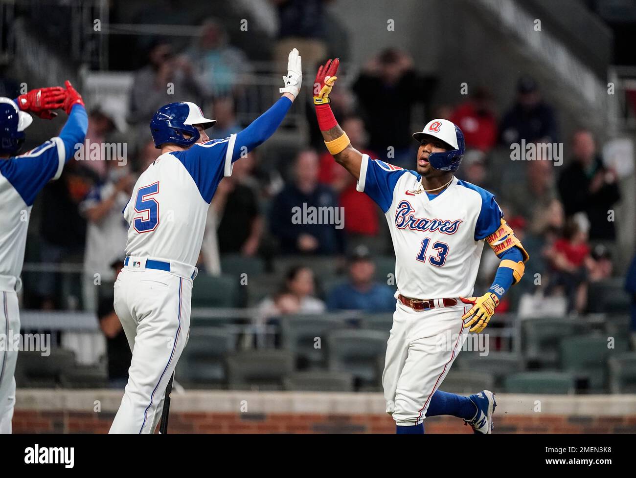 Atlanta Braves' Ronald Acuna Jr., right, high-five Freddie Freeman after  hitting a home run during the third inning of the team's baseball game  against the Miami Marlins on Wednesday, April 14, 2021