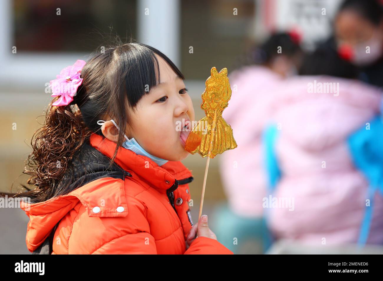 Tengzhou, China's Shandong Province. 22nd Jan, 2023. A girl tastes sugar painting in Xigang Township of Tengzhou, east China's Shandong Province, Jan. 22, 2023. People enjoy various kinds of cuisine in China during the Spring Festival holiday. Credit: Li Zhijun/Xinhua/Alamy Live News Stock Photo