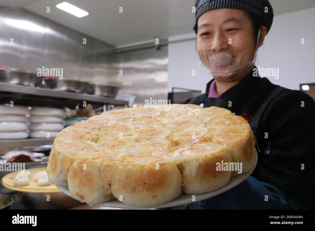 Gaomi, China's Shandong Province. 24th Jan, 2023. A chef displays local steamed stuffed buns at a restaurant in Gaomi, east China's Shandong Province, Jan. 24, 2023. People enjoy various kinds of cuisine in China during the Spring Festival holiday. Credit: Li Haitao/Xinhua/Alamy Live News Stock Photo