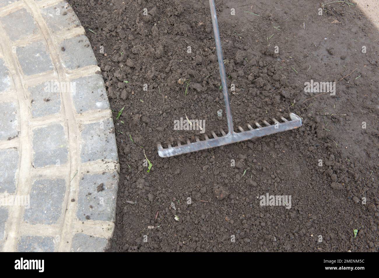 Raking soil in preparation for laying turf Stock Photo Alamy